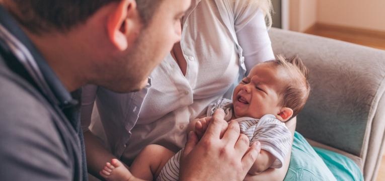 parentalidade com apego bebe a chorar com pais perto