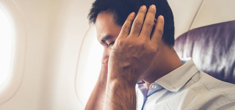 Homem a desentupir o ouvido no avião