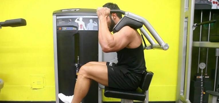 homem a executar abdominal sentado na máquina sem apoio das pernas