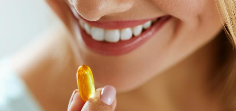 mulher a tomar suplementos multivitaminicos