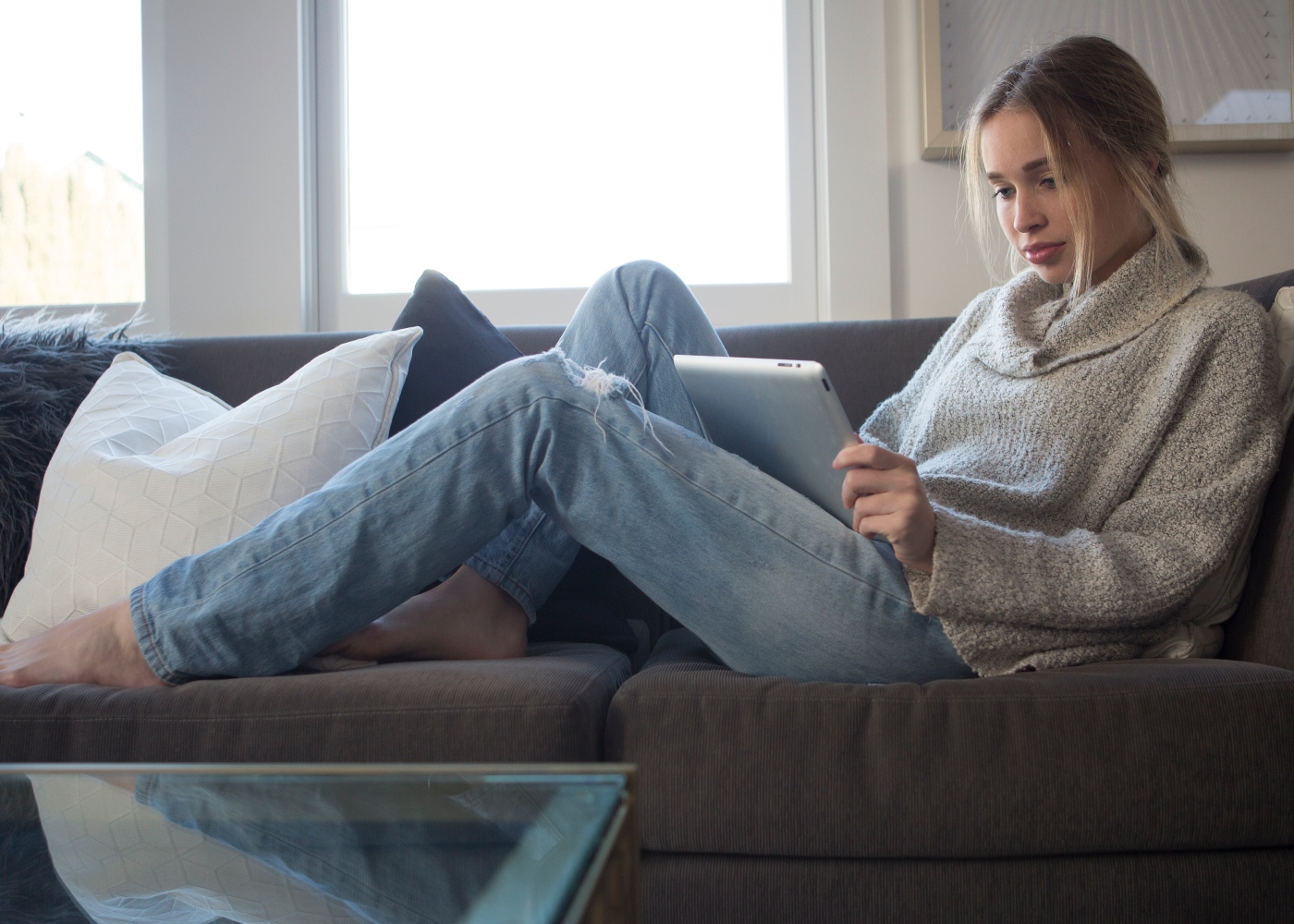 Como proteger a saúde mental em caso de isolamento: mulher em casa a ler um livro online