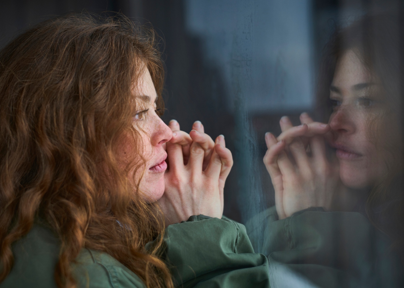 Gestão de stress e importância do exercício físico: mulher pensativa a olhar pela janela
