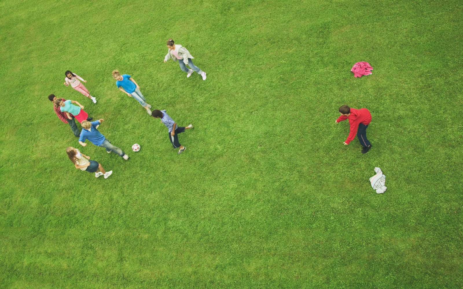 Grupo de crianças a jogar futebol