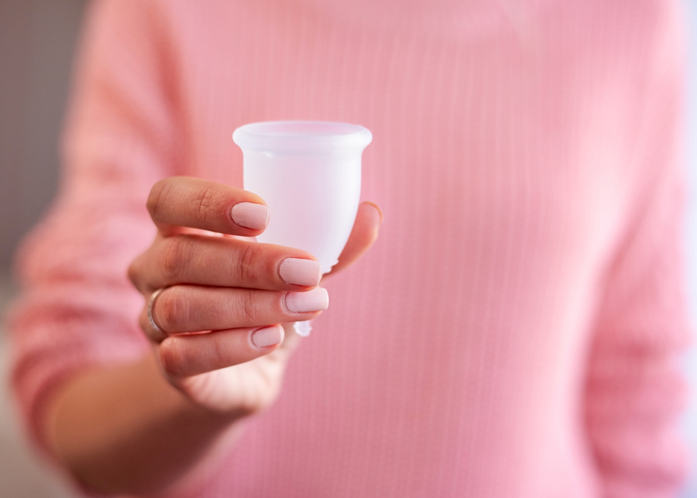 Mulher com copo menstrual na mão