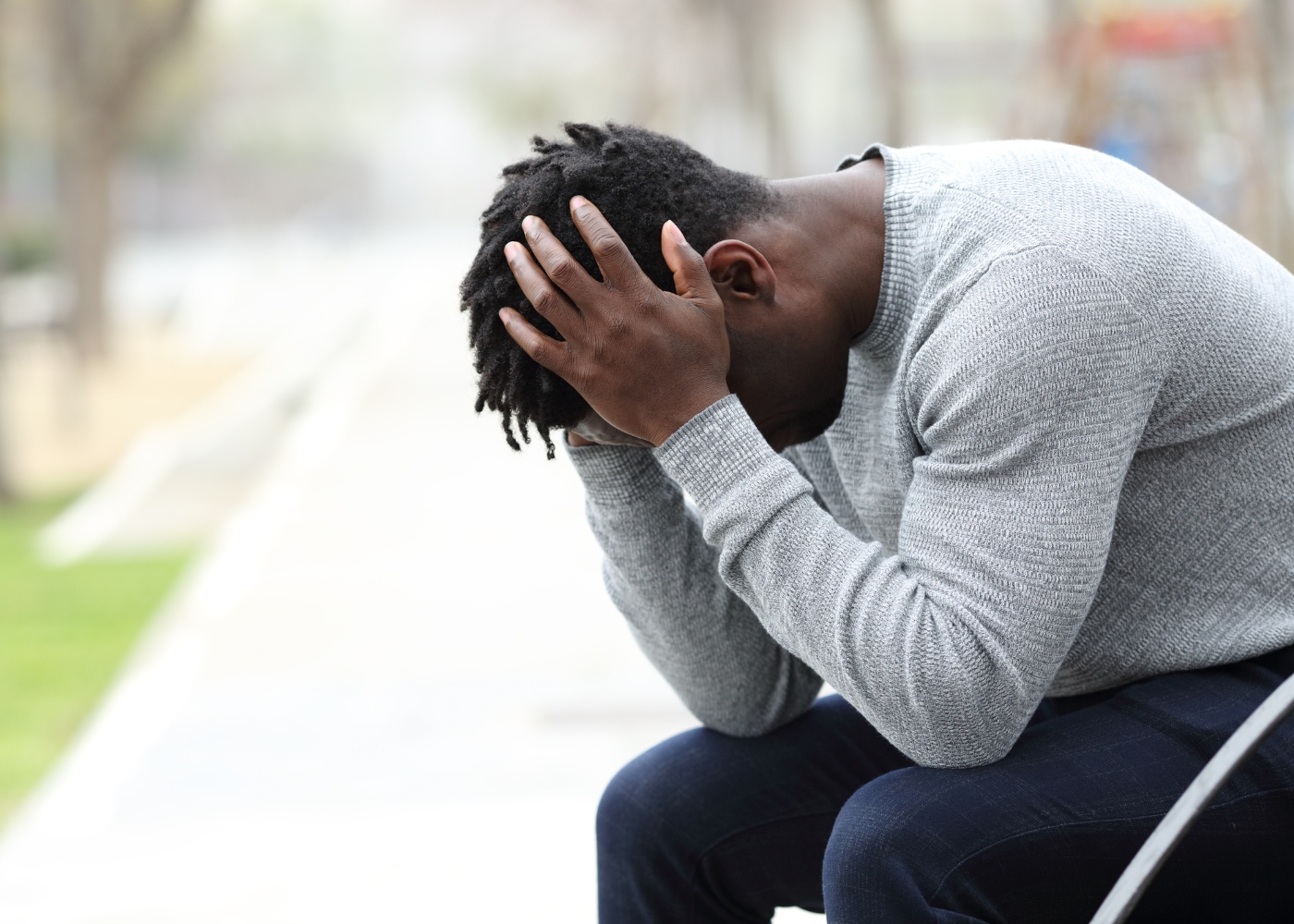 jovem stressado no banco de jardim